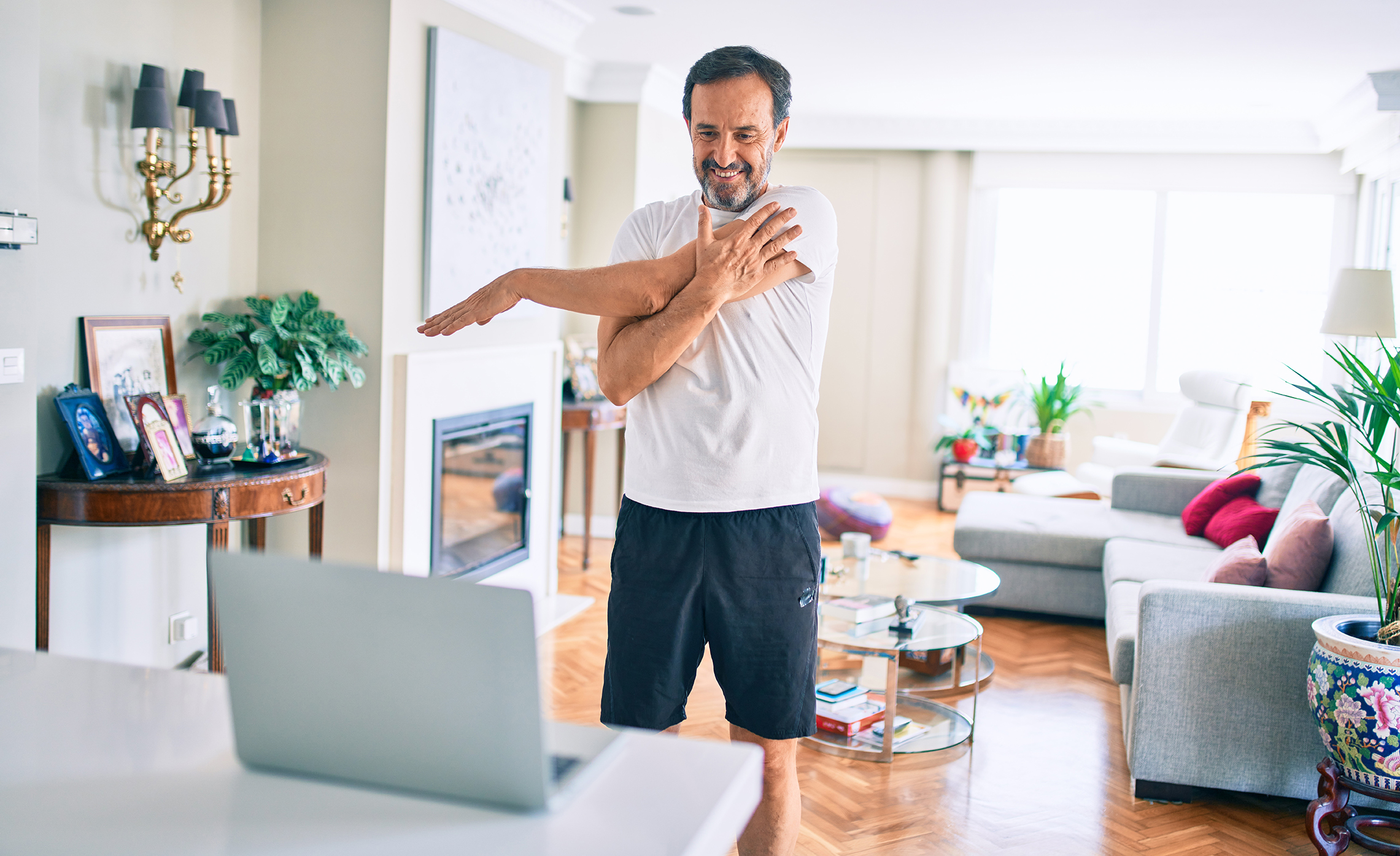 man exercising in front of laptop
